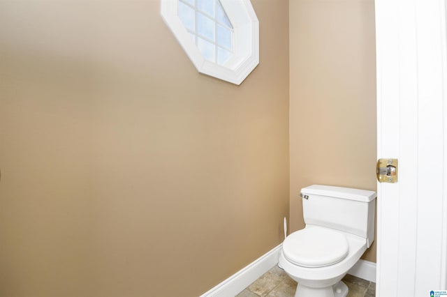 bathroom featuring tile patterned floors, baseboards, and toilet