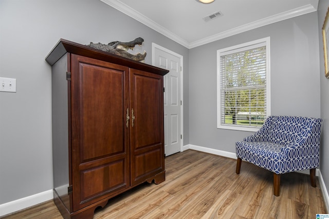 sitting room featuring crown molding, visible vents, baseboards, and light wood finished floors