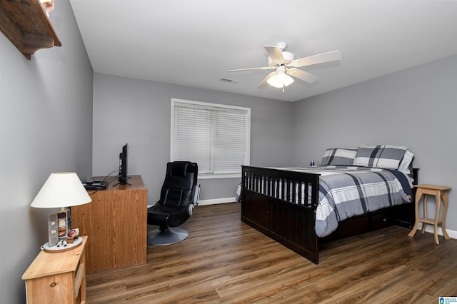 bedroom featuring ceiling fan, baseboards, visible vents, and wood finished floors