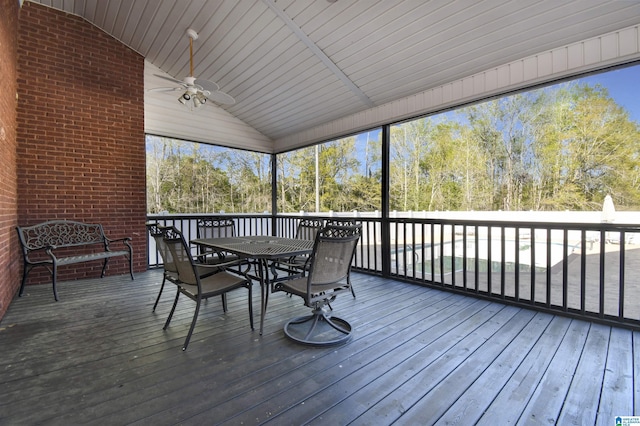 sunroom / solarium with outdoor dining space and a ceiling fan