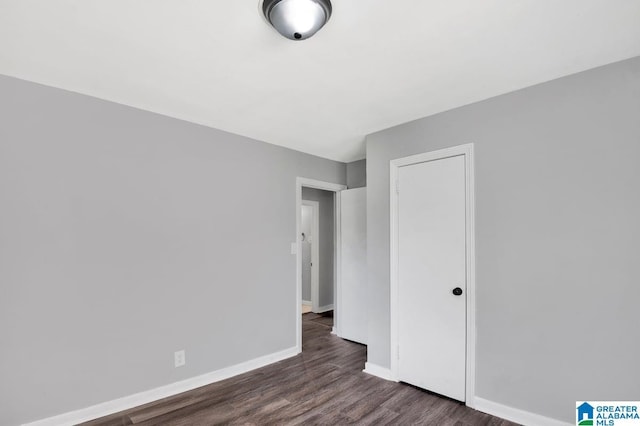 6616 4th Ave S, Birmingham, AL 35212 - unfurnished bedroom with a closet, baseboards, and dark wood finished floors