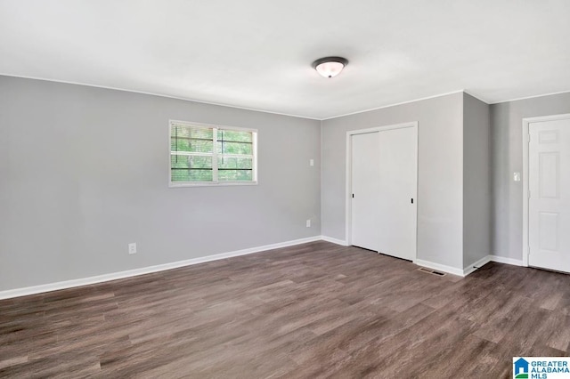 6616 4th Ave S, Birmingham, AL 35212 - unfurnished bedroom with a closet, dark wood-type flooring, visible vents, and baseboards