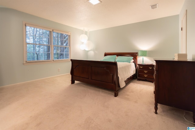 bedroom featuring visible vents, light colored carpet, and baseboards