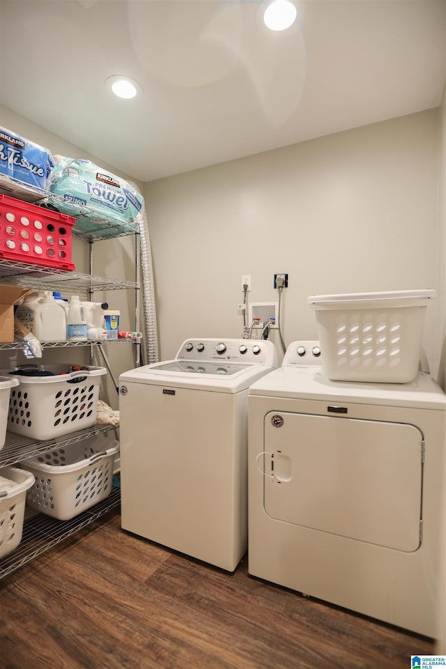 clothes washing area with laundry area, washing machine and clothes dryer, and wood finished floors