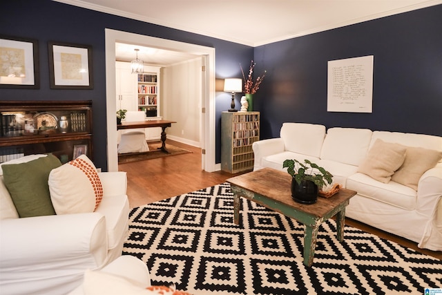 living area featuring ornamental molding, baseboards, and wood finished floors