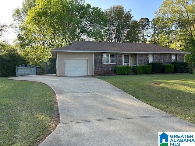 385 Cloverdale Dr, Sylacauga, AL 35150 - ranch-style house with a garage, a front yard, brick siding, and driveway