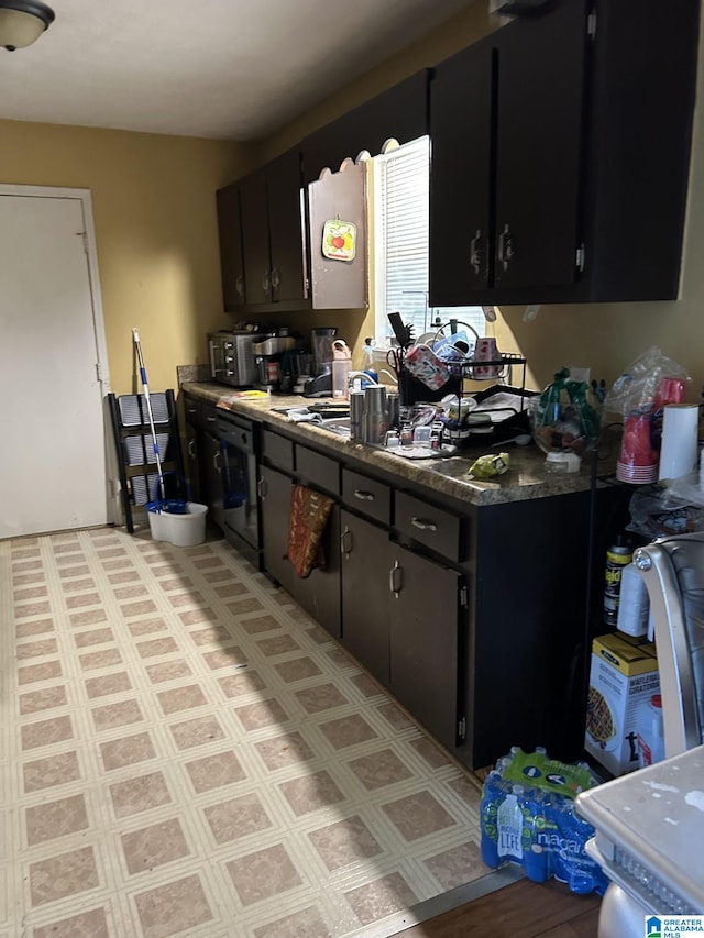385 Cloverdale Dr, Sylacauga, AL 35150 - kitchen with dark cabinetry, dark countertops, and dishwashing machine