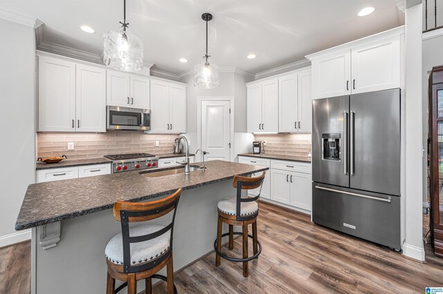 kitchen with tasteful backsplash, recessed lighting, white cabinets, stainless steel appliances, and a sink