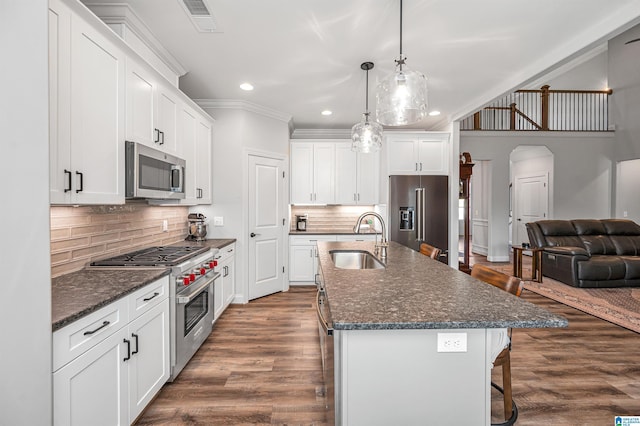 kitchen with a sink, high quality appliances, a kitchen breakfast bar, crown molding, and recessed lighting