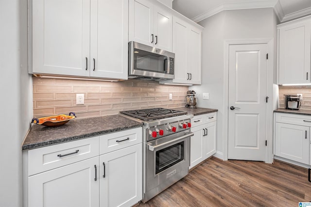 kitchen featuring crown molding, white cabinetry, dark wood-style flooring, stainless steel appliances, and decorative backsplash