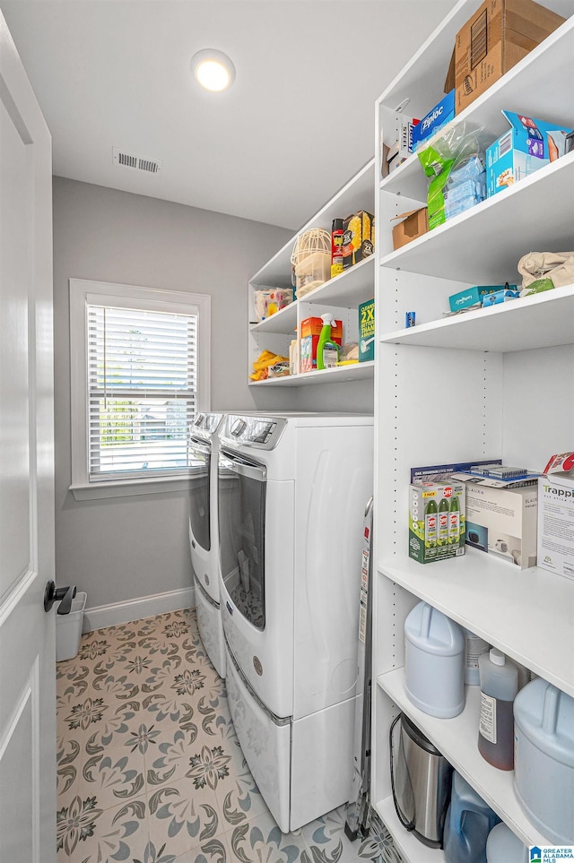laundry area with washing machine and dryer, laundry area, baseboards, and visible vents