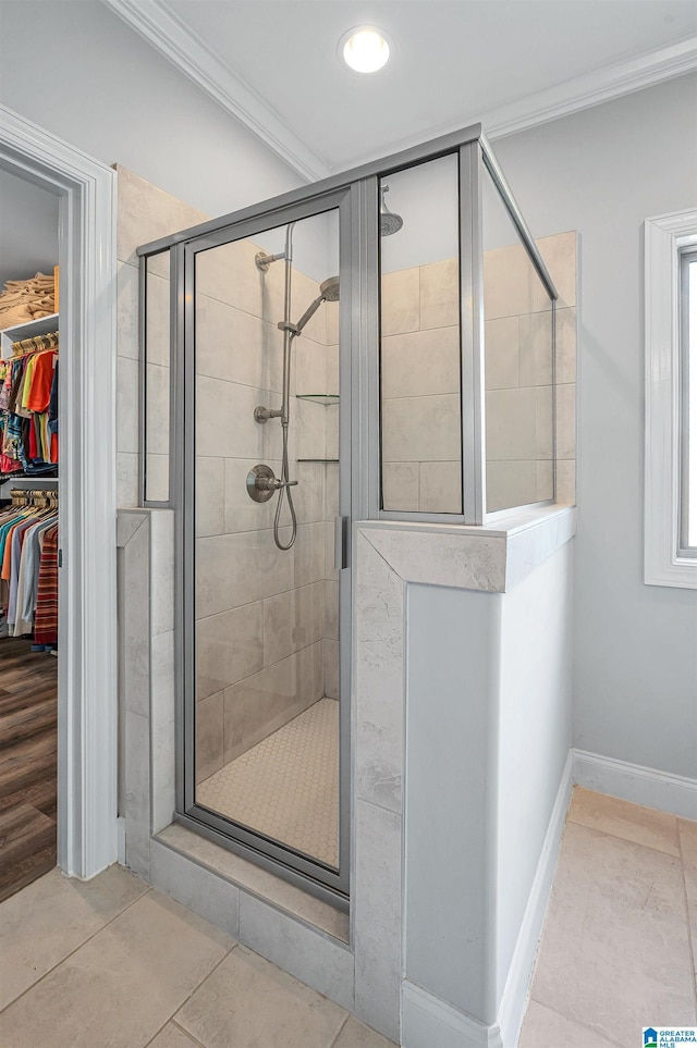 full bath featuring a walk in closet, ornamental molding, baseboards, and a shower stall