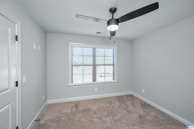 carpeted empty room featuring visible vents, baseboards, and a ceiling fan