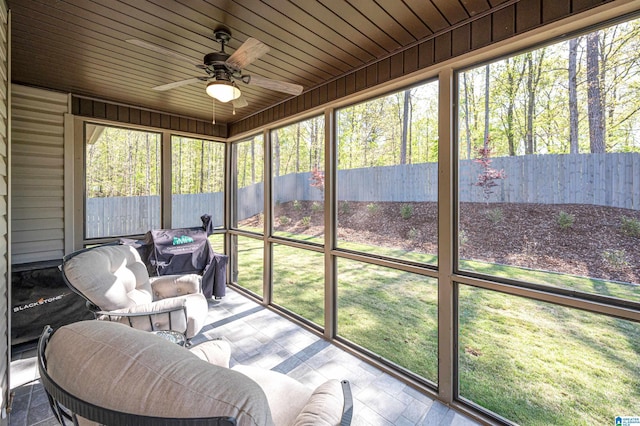 sunroom / solarium featuring a healthy amount of sunlight and ceiling fan