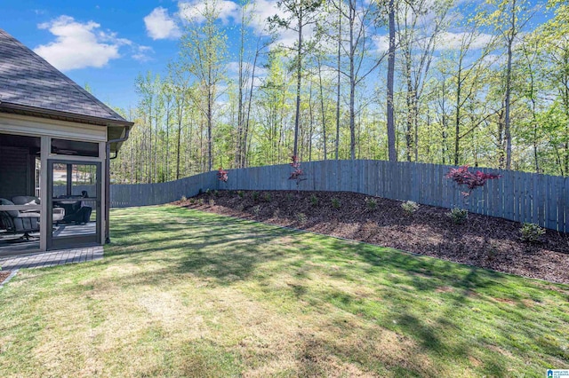 view of yard featuring a sunroom and a fenced backyard