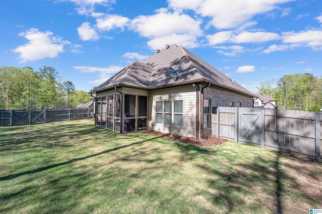 rear view of house featuring a sunroom, a fenced backyard, a lawn, roof with shingles, and a gate