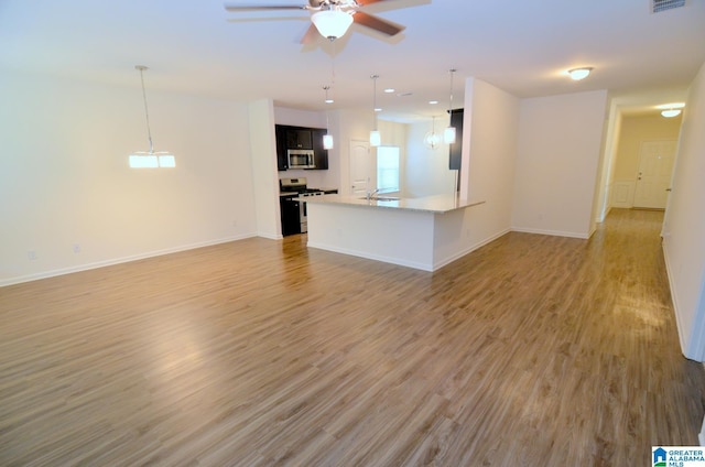 unfurnished living room with a ceiling fan, a sink, light wood-type flooring, baseboards, and recessed lighting
