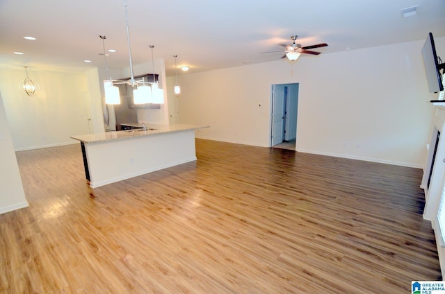 unfurnished living room featuring a ceiling fan, baseboards, recessed lighting, and light wood-style floors