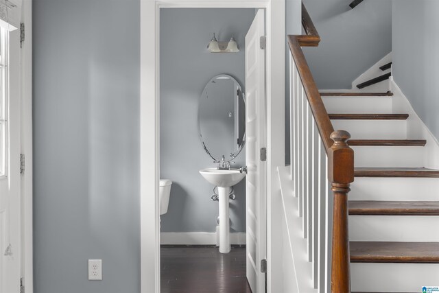 staircase featuring baseboards and wood finished floors