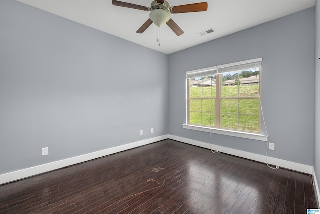 spare room with a ceiling fan, baseboards, dark wood finished floors, and visible vents
