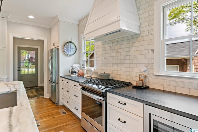1119 Crest Ave, Homewood, AL 35209 - kitchen with white cabinets, appliances with stainless steel finishes, premium range hood, and beverage cooler