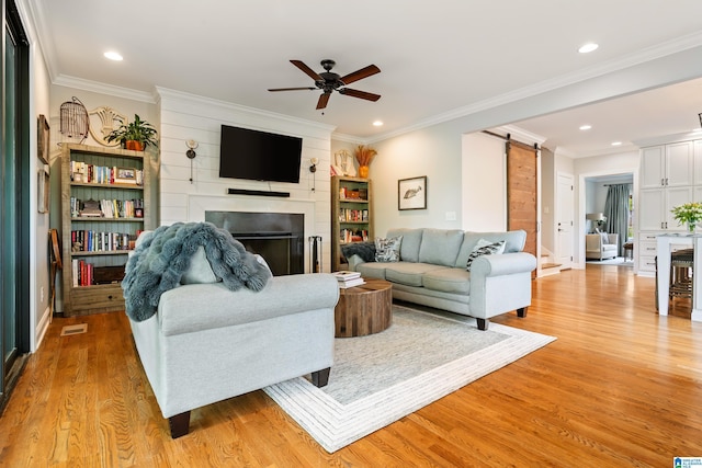 1119 Crest Ave, Homewood, AL 35209 - living room with light wood-style floors, ceiling fan, a fireplace, recessed lighting, and a barn door