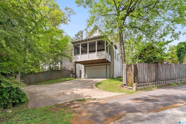 1119 Crest Ave, Homewood, AL 35209 - view of front of house featuring a sunroom, an attached garage, ceiling fan, fence, and driveway