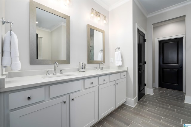 full bathroom featuring double vanity, a sink, ornamental molding, and baseboards