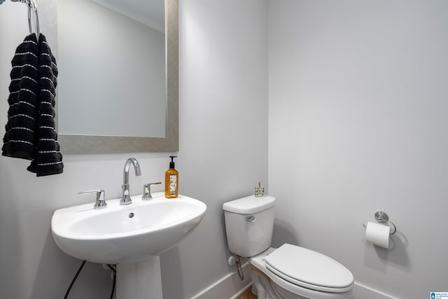 bathroom with baseboards, a sink, and toilet