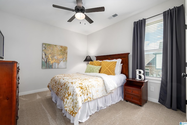 bedroom with visible vents, light colored carpet, and baseboards