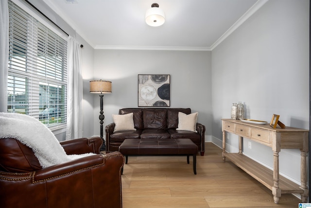 living room featuring crown molding, baseboards, and light wood-type flooring