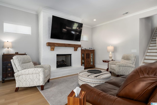 living area featuring crown molding, visible vents, wood finished floors, stairs, and baseboards