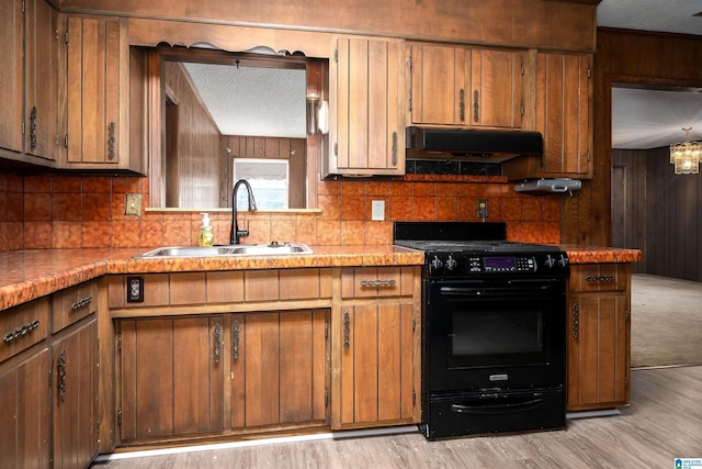 701 11th Pl, Pleasant Grove, AL 35127 - kitchen with tasteful backsplash, a sink, under cabinet range hood, light wood finished floors, and gas stove
