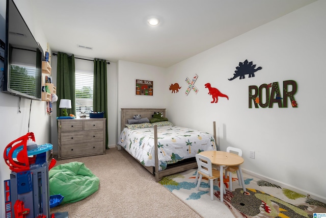 bedroom featuring visible vents, light colored carpet, and baseboards