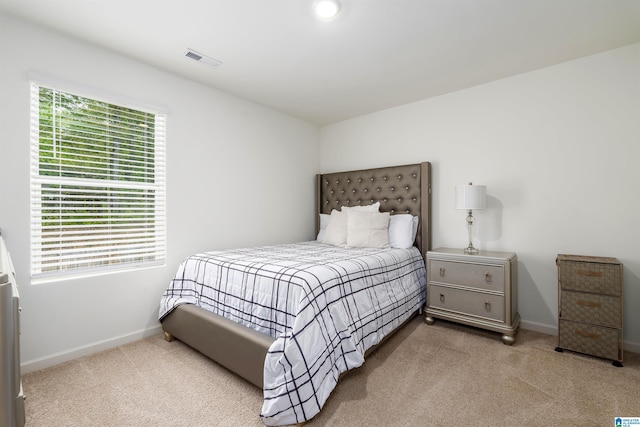 carpeted bedroom featuring visible vents, baseboards, and multiple windows