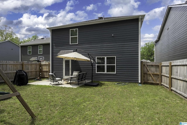back of property with a patio, a fenced backyard, and a yard