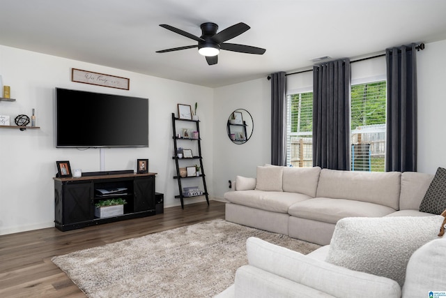 living area featuring visible vents, ceiling fan, wood finished floors, and baseboards