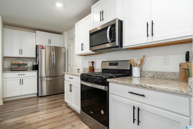 kitchen featuring light stone counters, recessed lighting, light wood-style flooring, white cabinetry, and appliances with stainless steel finishes