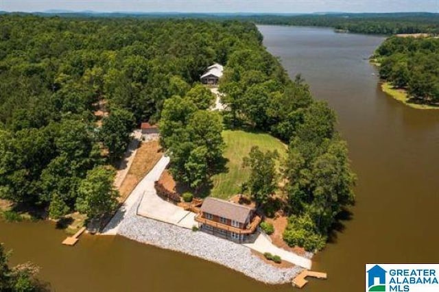 drone / aerial view featuring a water view and a wooded view
