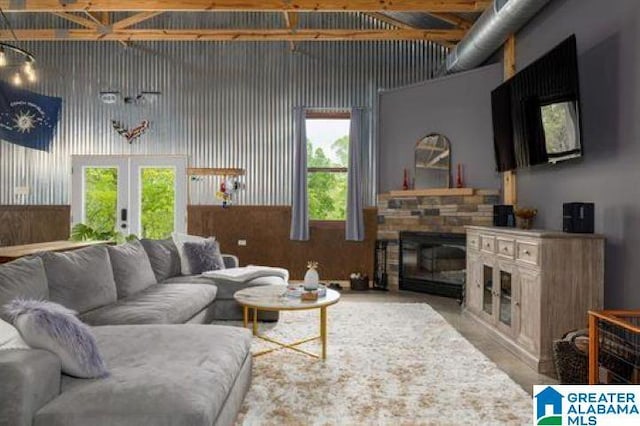 living room with a stone fireplace and french doors