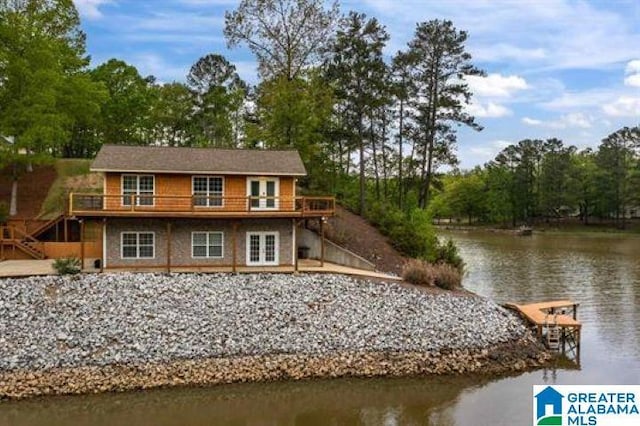 exterior space with stairway, french doors, and a deck with water view