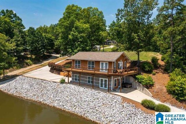rear view of house featuring french doors, a patio area, and a deck with water view