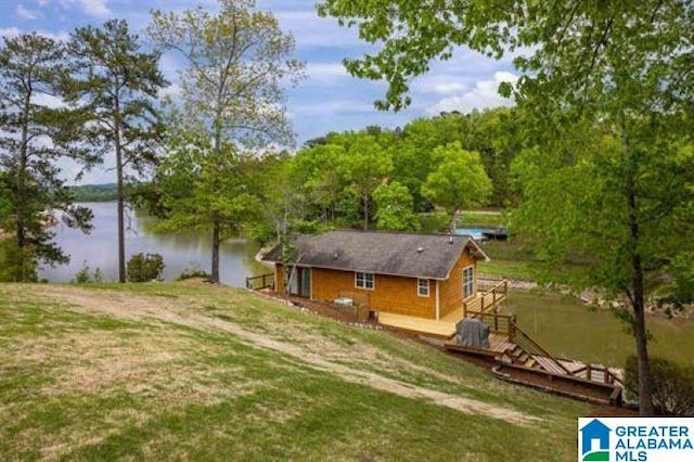 view of yard with a deck with water view