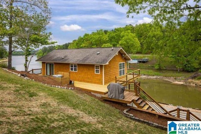 back of property with a deck with water view