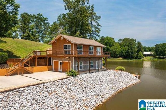 back of house with a deck with water view, stairs, and a patio