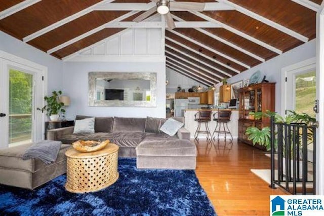 living room with wood ceiling, ceiling fan, wood finished floors, and vaulted ceiling with beams