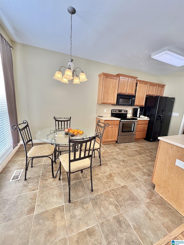kitchen featuring visible vents, light brown cabinets, light countertops, a chandelier, and black appliances