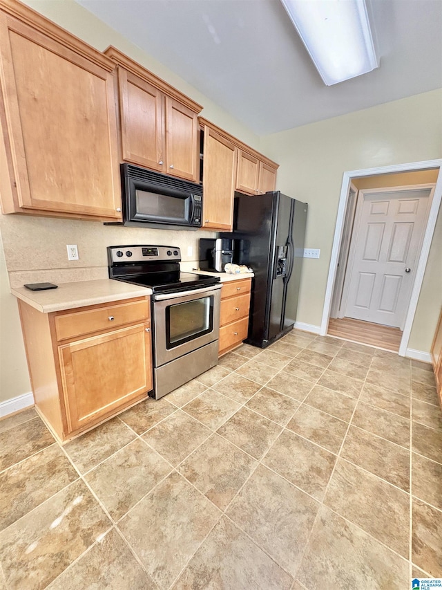 kitchen with baseboards, light countertops, and black appliances