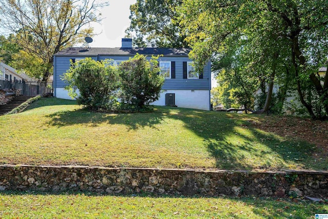 exterior space featuring a front yard, stairs, and a chimney