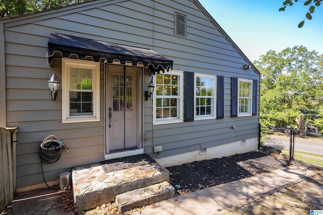 entrance to property with fence and crawl space